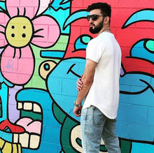 Load image into Gallery viewer, Male model wearing a Fauna off white hemp and organic cotton shirt. Standing in front of a graffiti wall in Los Angeles, California.