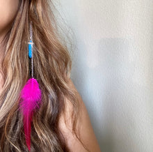 Load image into Gallery viewer, Woman wearing a Fauna hair clip jewelry made of 2 stainless steel chains with a cruelty free fuchsia rooster feather on one end and a faux turquoise pendant on the other.
