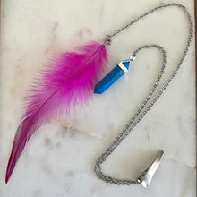 Load image into Gallery viewer, Close-up of Fauna hair clip jewelry made of 2 stainless steel chains with a cruelty free fuchsia rooster feather on one end and a faux turquoise pendant on the other.
