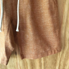 Load image into Gallery viewer, Close-up of FAUNA Kids Rust Orange Sustainable Hemp Shorts featuring 2 front pockets, a comfortable crotch inset, a waistband with organic cotton rope to adjust to child's waist size, and lots of love to Mother Earth.
