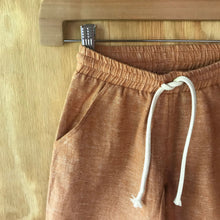 Load image into Gallery viewer, Close-up of FAUNA Kids Rust Orange Sustainable Hemp Shorts featuring 2 front pockets, a comfortable crotch inset, a waistband with organic cotton rope to adjust to child's waist size, and lots of love to Mother Earth.
