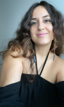 Load image into Gallery viewer, Woman wearing a Fauna organic cotton gauze off shoulder blouse and healing crystals as jewelry with these beautiful long shoulder duster earrings. Made from a stainless steel chain with a Rainbow Aura Quartz crystal at the end, connected to stainless steel french hook ear wires.
